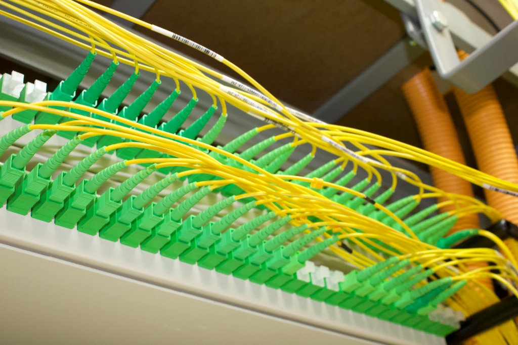 Fiber patch cords landing in rows of connectors on a patch panel, cabled and labelled to the design