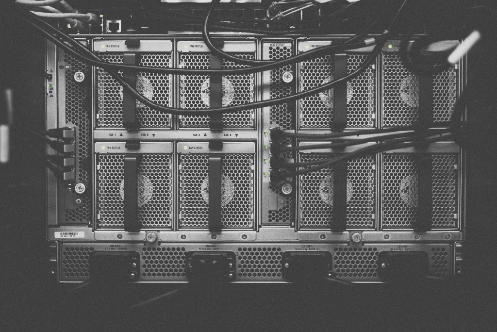 Rear of a chassis switch in black and white: fan trays, power supplies and cabling