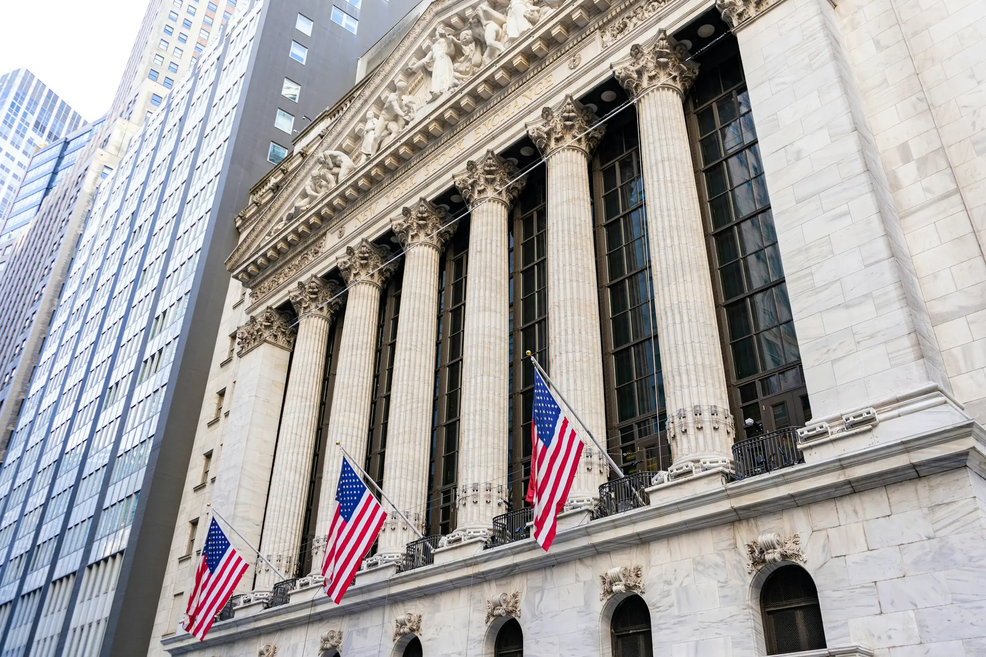 The New York Stock Exchange on Wall Street, American flags along its columns