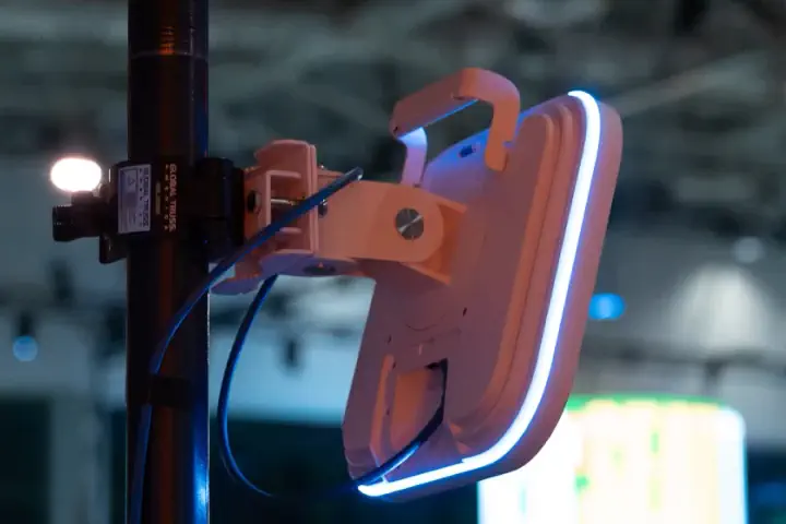 An access point we deployed on a mast in the hall at Shopify Summit 2025, the show's screens behind it