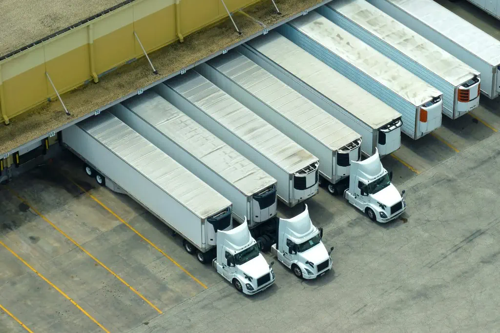 Semi trucks parked in rows at a distribution yard