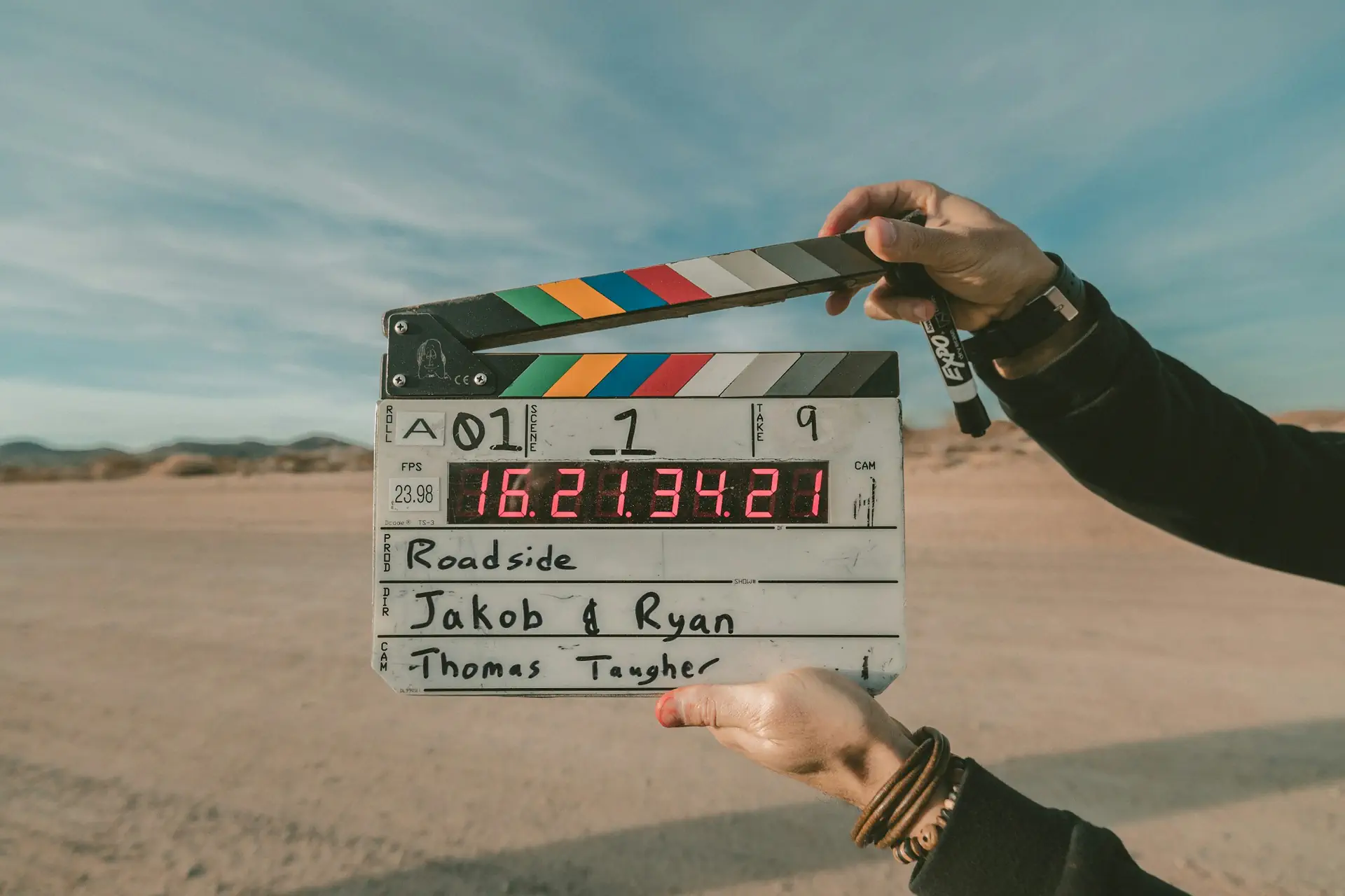 A film slate held up on location before a take, the production side of a media network