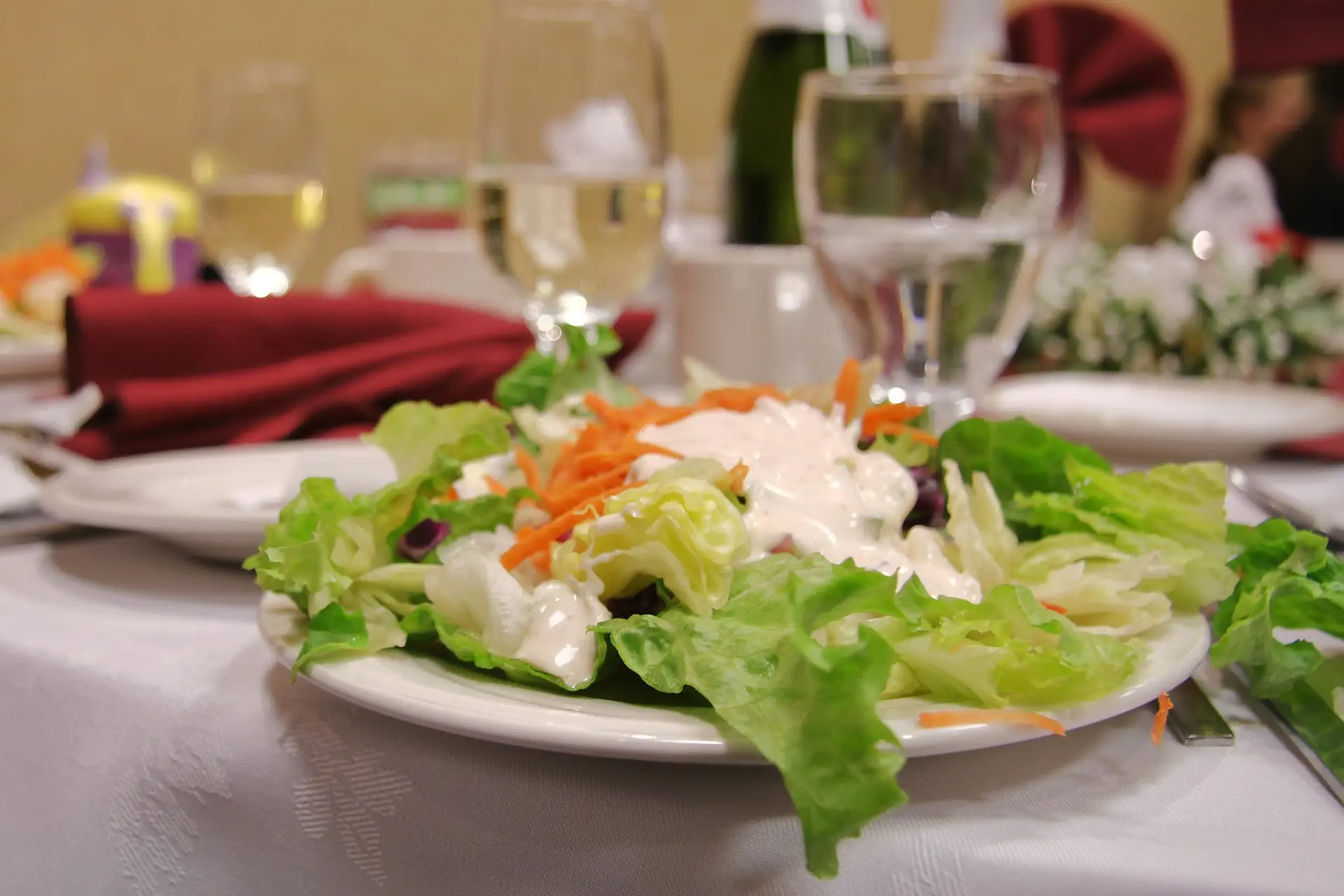 A plated salad on a white tablecloth at a restaurant table, the floor that POS, guest Wi-Fi and cameras cover