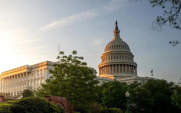 The United States Capitol at dusk behind its gardens