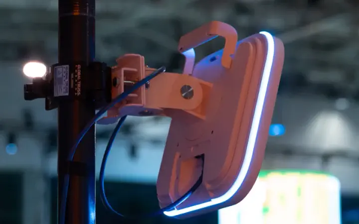 An access point we deployed on a mast in the hall at Shopify Summit 2025, the show's screens behind it