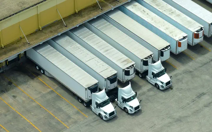 Semi trucks parked in rows at a distribution yard