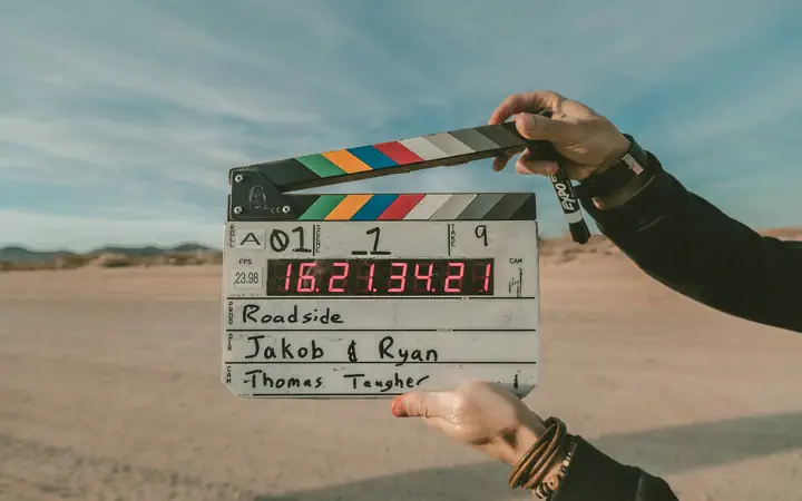 A film slate held up on location before a take, the production side of a media network