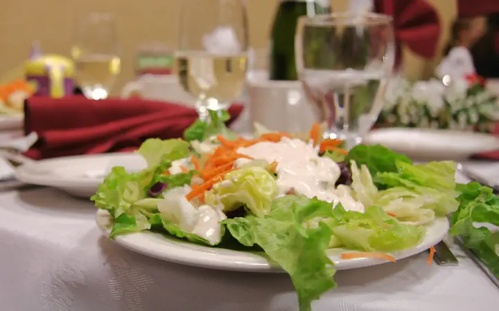 A plated salad on a white tablecloth at a restaurant table, the floor that POS, guest Wi-Fi and cameras cover