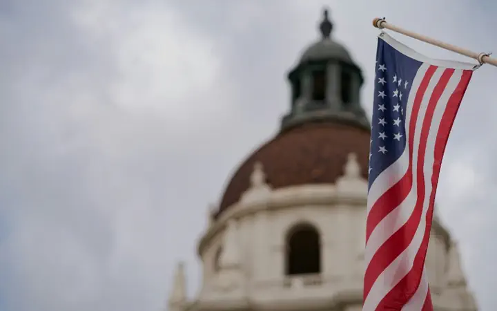 A domed county courthouse with the American flag beside it