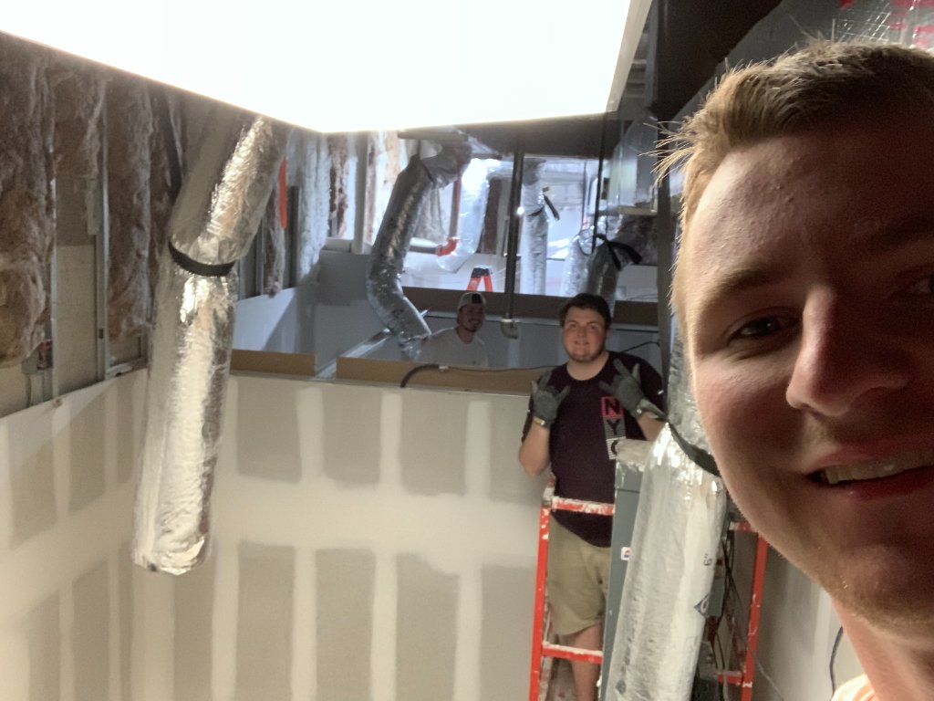 Cody Franklin on a lift above the ceiling, pulling cable on an early deployment